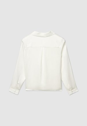 Blouse en satin blanc avec un empiècement dans le dos, manches longues et poignets boutonnés. Texture lisse avec une coupe décontractée et un design minimaliste.