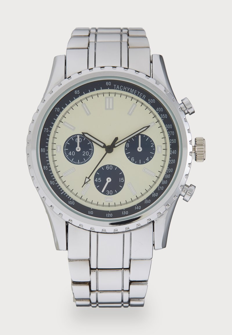Montre chronographe en acier inoxydable argenté avec un boîtier rond, un cadran crème, des sous-cadrans noirs, une échelle tachymétrique et un bracelet à maillons poli.