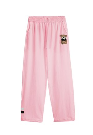 Pantalones sueltos rosas con cintura elástica que presentan un pequeño dibujo de un osito en la parte superior del muslo izquierdo y una etiqueta cerca del dobladillo inferior.
