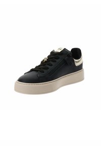 Sneaker in pelle nera con suola in gomma beige. Presenta un accento dorato sul tallone, una cerniera laterale e lacci neri. Dettagli testurizzati sulla suola.