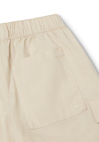 Béžové cargo šortky mají elastický pas, boční kapsu a vyšívané logo na zadní kapse, vyrobené z lehkého materiálu.