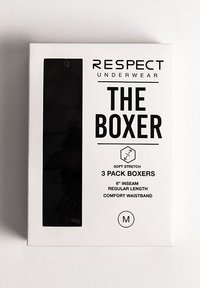 Fekete boxer alsónadrág háromszoros csomagolás, átlátszó ablakkal, merész fekete szöveggel és fehér háttérrel. M-es méret, puha, rugalmas anyag.