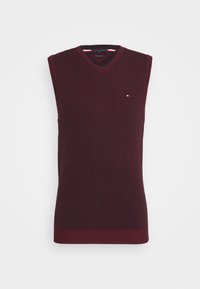 Bordeauxrode mouwloze V-hals trui gemaakt van gebreide stof, met een geribde zoom en een klein logo in contrasterende kleuren op de borst.