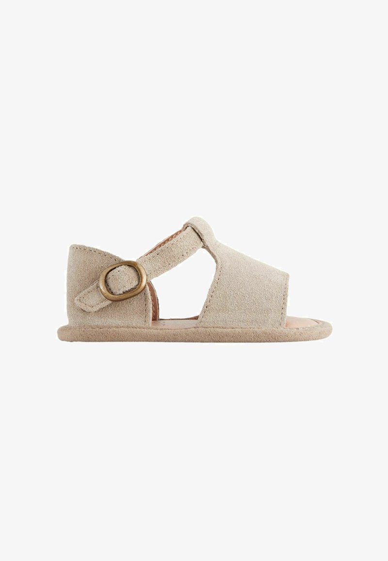 Sandale bébé en daim beige avec bout ouvert, découpe latérale et bride réglable avec boucle couleur laiton.