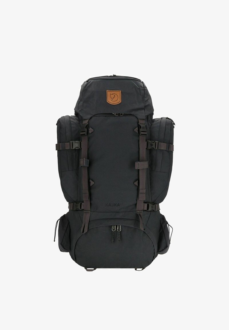 Mochila preta feita de tecido durável, com múltiplos compartimentos, alças ajustáveis e um emblema em couro. Adequada para uso ao ar livre.