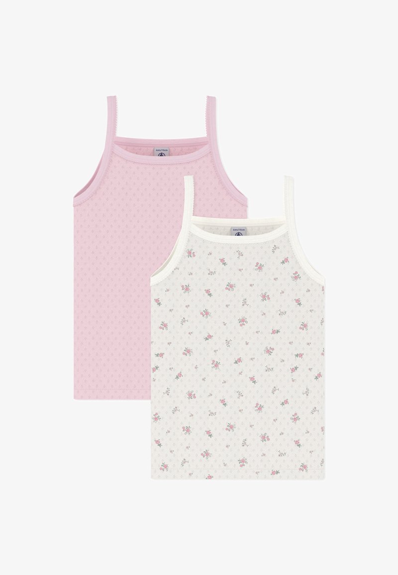 Δύο μπλουζάκια χωρίς μανίκια: ένα μονόχρωμο ανοιχτό ροζ με υφή, και ένα λευκό με μικρό λουλουδάτο μοτίβο. Και τα δύο έχουν λεπτές τιράντες και απαλό ύφασμα.