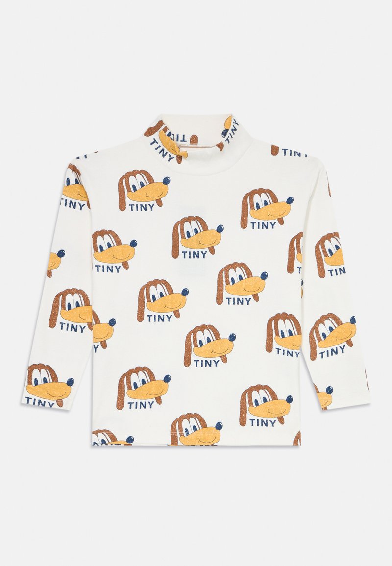 Langermet hvit topp med et gjentakende mønster av tegneseriehundansikt og ordet "TINY" i blått, med en høy halsdesign.