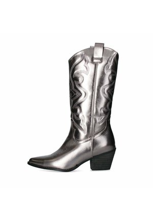 Bota de cowboy plateada metálica con punta afilada, patrones de costura intrincados y un pequeño tacón cuadrado; cuenta con un lazo en la parte superior para facilitar su uso.