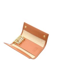 Portafoglio in pelle marrone chiaro con finitura texture, dotato di sei slot per carte, hardware dorato e chiusura a snap. Rivestito in tessuto beige chiaro.