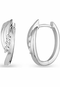 Silver hoop earrings featuring a wavy design, three small clear gemstones, and a polished finish. Modern and minimalistic in style.