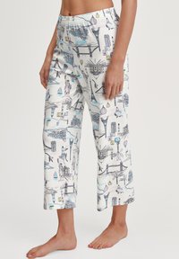 Pantalons de pyjama en coton avec un fond blanc et un imprimé de paysage urbain coloré. Le design comprend des monuments emblématiques en bleu, violet et noir.