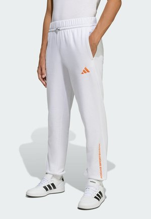 Pantaloni della tuta bianchi con un elastico in vita, con logo e testo arancione Adidas sul lato. Inclusi tasche laterali e una vestibilità rilassata.