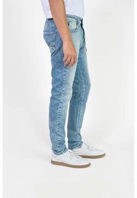 Lichtblauwe denim jeans met een slim fit, voorzien van een klassieke vijf-pocket stijl en een vervaagde wassing. Draag ze met witte sneakers.