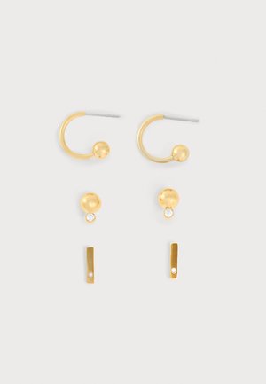 Ensemble de trois paires de boucles d'oreilles ton or comprenant des petites créoles avec des sphères, des puces rondes avec de minuscules cristaux, et des barres fines avec cristaux.