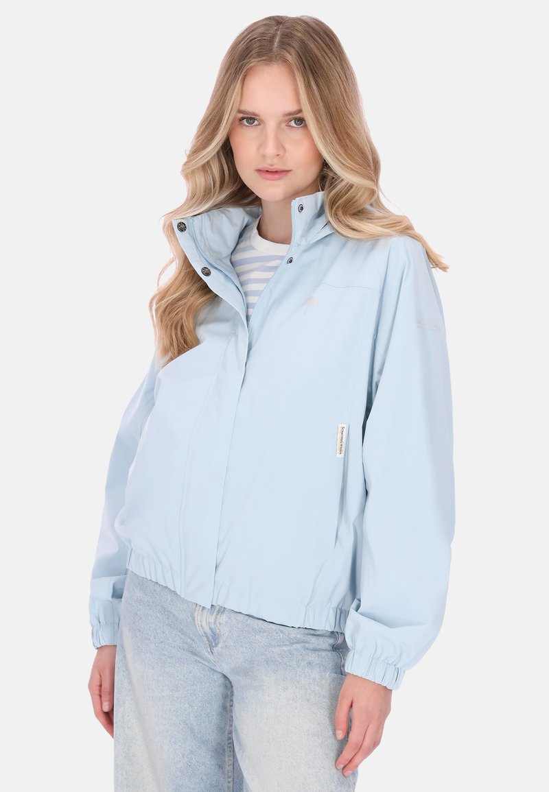 Vaaleansininen tuulitakki, jossa on korkea kaulus, joustavat hihansuut ja rento istuvuus. Takissa on painonapit ja hienovarainen logotunnus.