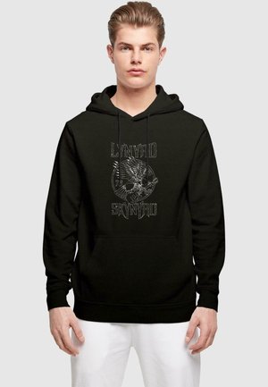 Sudadera negra con un gráfico frontal de un águila y una guitarra con el texto "LYNYRD SKYNYRD 73". Material de algodón, capucha con cordones, bolsa frontal.