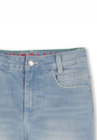 Lichtblauwe denim jeans met een rafelige rand bij de zak, zilveren knoopsluiting en subtiele vervaging. Rood label zichtbaar aan de binnenkant van de tailleband.