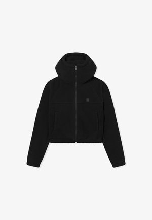 Chaqueta de forro polar negra corta con alto cuello, cierre de cremallera y dos bolsillos frontales. Textura suave con diseño minimalista y acento de logotipo.