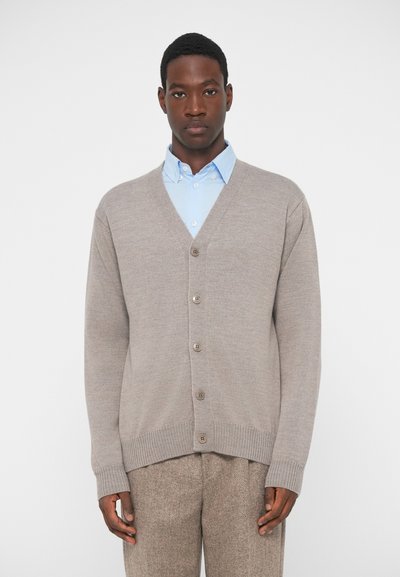 Light brown cardigan with a V-neck, ribbed cuffs, and five buttons down the front, layered over a light blue collared shirt.