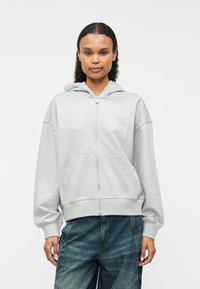 Γκρι φούτερ με φερμουάρ και χαλαρή εφαρμογή, κουκούλα με κορδόνι, μπροστινές τσέπες και κεντημένο λογότυπο στο στήθος. Μαλακό υλικό βαμβακιού.