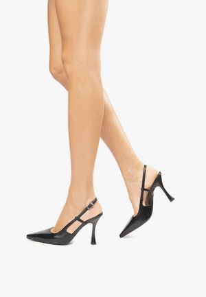 Tacchi slingback in pelle nera con punta affusolata, tacco sottile e cinturino alla caviglia con chiusura a fibbia. Superficie liscia con finitura lucida.