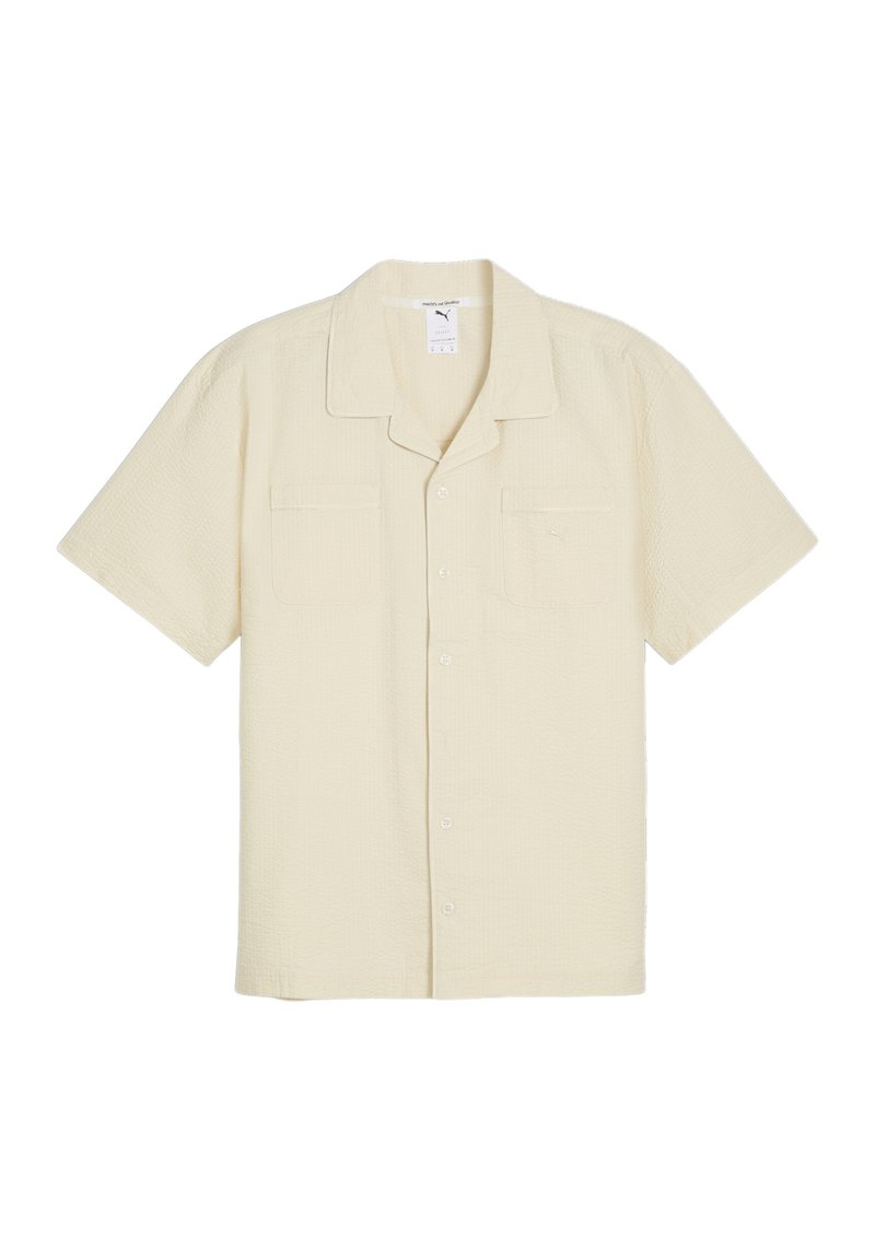 Camicia a maniche corte, con bottoni, in tessuto giallo chiaro testurizzato, dotata di due tasche frontali e colletto. Logo discreto sul lato sinistro.