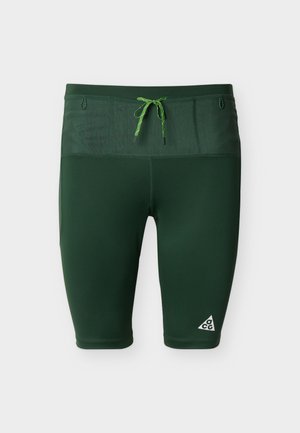 Pantaloncini sportivi aderenti di colore verde scuro con coulisse verde chiaro e logo ACG sulla gamba sinistra.
