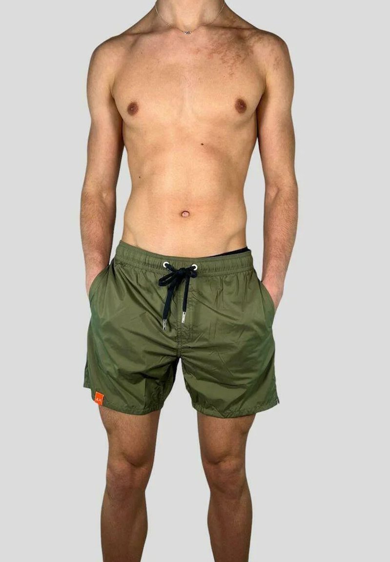 Pantaloni da bagno verde oliva realizzati in materiale leggero, dotati di vita elastica, chiusura con coulisse e tasche laterali.