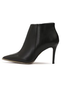 Bottine en cuir noir à bout pointu avec talon stiletto haut et fin, bordée d'une subtile garniture dorée le long du bord de la semelle.