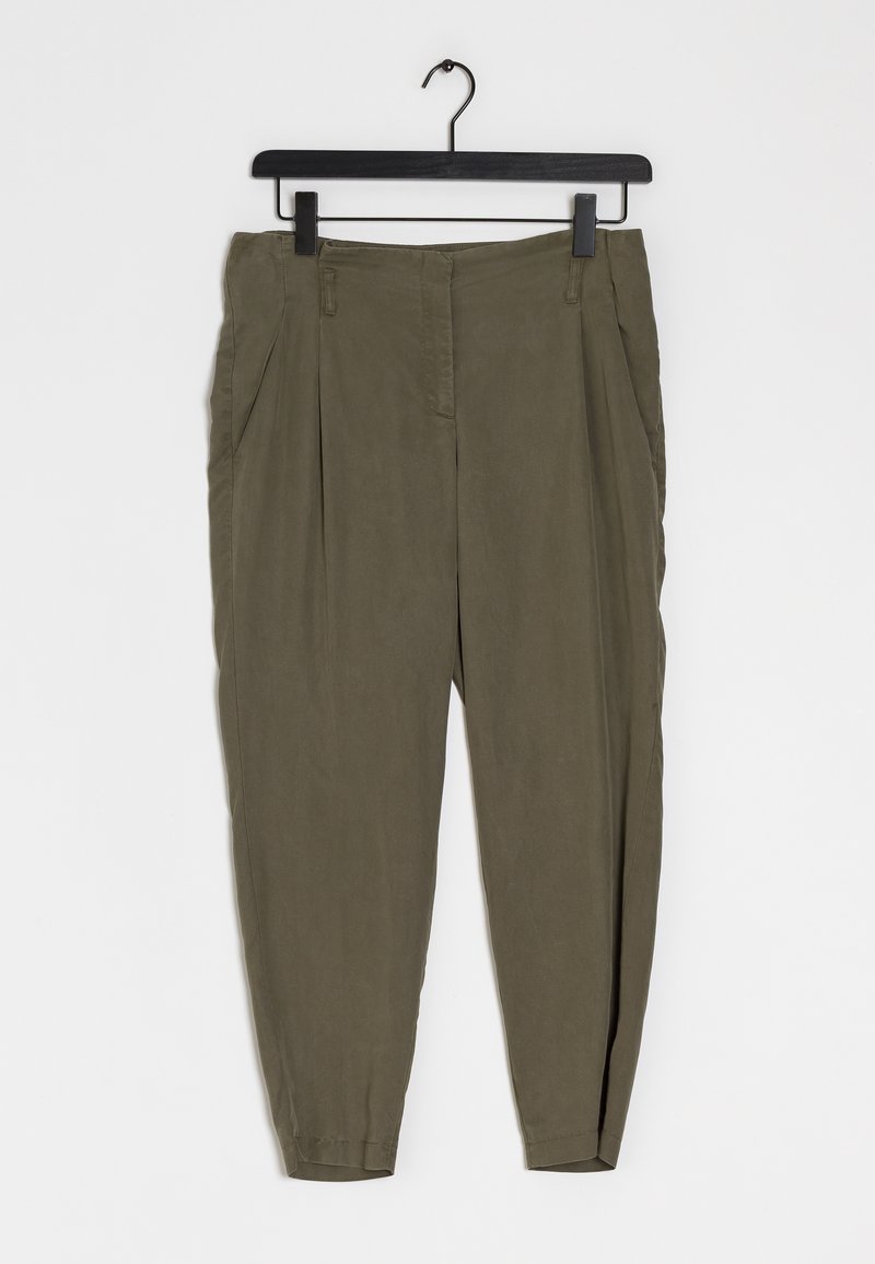 Pantalon plissé kaki avec une texture lisse, une coupe fuselée et une ceinture plate. Suspendu sur un cintre noir contre un fond blanc.