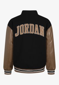 Czarna kurtka typu varsity z brązowymi skórzanymi rękawami, z napisem "JORDAN" wyhaftowanym na beżowo na plecach oraz żebrowanymi paskowanymi mankietami i u dołu.
