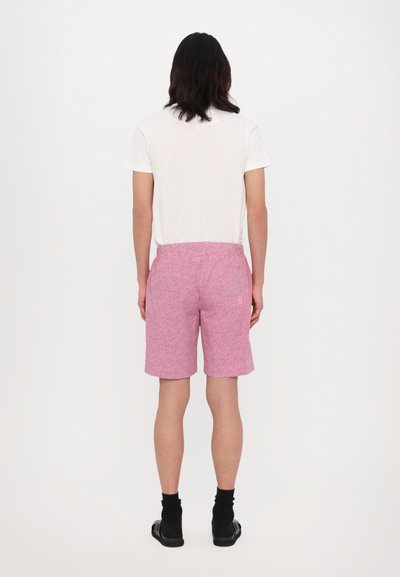 Roze gebloemde shorts gemaakt van lichtgewicht stof, met een elastische tailleband en een achterzak. Gecombineerd met een eenvoudig wit T-shirt.