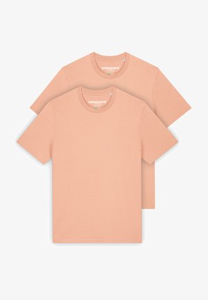 Deux t-shirts à manches courtes d'une douce couleur pêche. Fabriqués en tissu lisse, avec des cols ronds et un design minimaliste.