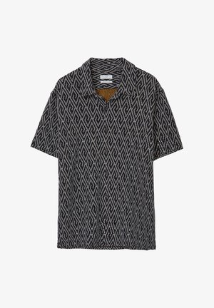 Chemise à manches courtes avec un motif en diamants noir et blanc, fermeture à boutons et col évasé. Le tissu a une finition texturée.