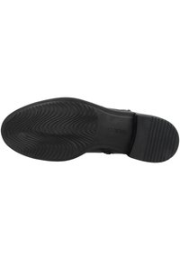 Sole di scarpa nera in gomma con un motivo testurizzato e ondulato per una migliore trazione. Presenta un tacco leggermente rialzato e una finitura liscia lungo i bordi.