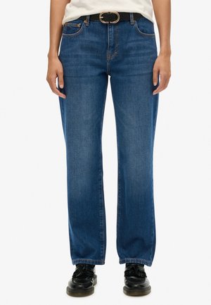 Blauwe denim jeans met een rechte pijpdesign, riemlussen en contrasterend stiksels. Gecombineerd met zwarte schoenen en een bijpassende riem.