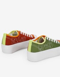 Canvas sneakers with a flat white sole. One shoe is red with "rules" in white stitching, the other is green with "break" in white stitching.