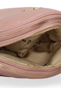 Borsa in pelle rosa con apertura a zip e dettagli in oro. Interno foderato con un tessuto beige che presenta un delicato motivo con il logo.