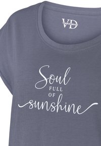 Grå t-shirt med kort ärm som har vit kursiv text som säger "Själ med solens ljus" centrerad över bröstet. Mjuk tygstruktur.