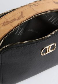 Bustina nera texturizzata con logo dorato, sezione superiore color cuoio stampata con una vecchia mappa e cerniera dorata visibile parzialmente aperta che mostra la fodera interna nera.