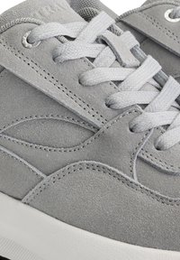 Baskets en suède gris avec une tige texturée, des coutures contrastantes, des lacets plats gris et une semelle en caoutchouc blanche. Comprend des œillets métalliques.