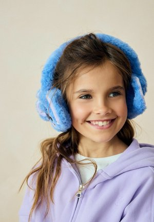 Blauwe nepbont oorwarmers met een zachte textuur, in een ronde vorm en met contrasterende roze accenten. Draagt een jong meisje in een lavendelkleurige hoodie.