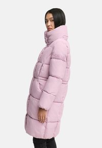 Puffy pink long coat with high collar, quilted design, side pockets, and embroidered details on the sleeve. Smooth, lightweight fabric.