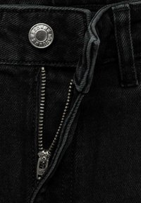Black denim jeans featuring a silver button closure and an unzipped silver zipper with visible teeth detail, showcasing a textured fabric.