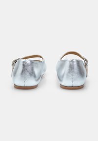 Ballet flats metallici argento con punta arrotondata e fascia posteriore con una piccola fibbia. Texture liscia e design minimalista.