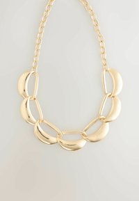 Chunky goldene Halskette mit großen, geschwungenen, mondförmigen Gliedern, die durch längliche ovale Glieder auf einem Kettenhintergrund miteinander verbunden sind.