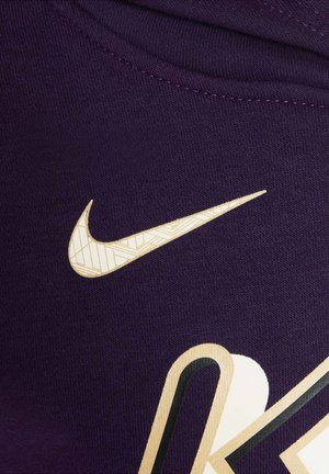 Purple fabric with a textured weave, featuring a white Nike logo with a geometric pattern and a bold black accent design.