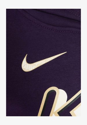 Violetti kangas, jossa on strukturoitu kudos, esittelee valkoista Nike-logoa, jossa on geometrinen kuosi ja voimakas musta korostusmuotoilu.