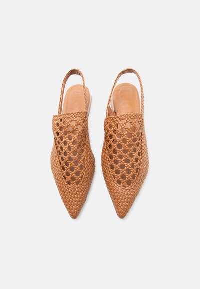 Pruunide punaste pöötidega sukapaelaga põimitud nahast madalad kingad keerukate avatud punumismustritega valgel taustal.