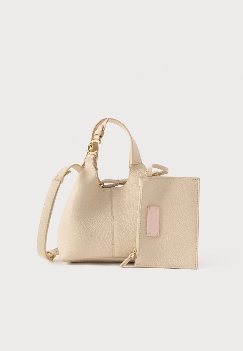 Sac à main en cuir texturé beige avec bandoulière réglable et pochette assortie zippée, présentant une petite étiquette rose sur fond blanc.